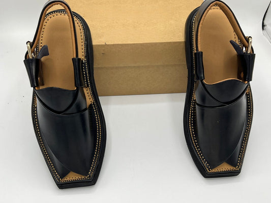 Pair of black shoes with brown accents on a white background