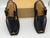 Pair of black shoes with brown accents on a white background