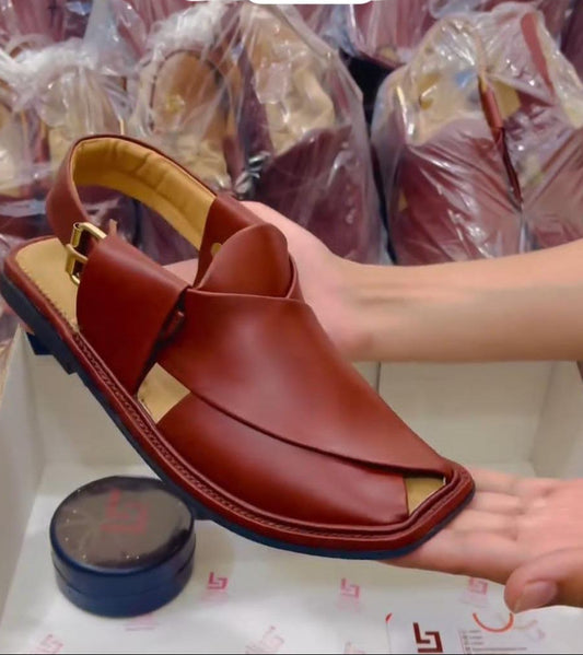 Brown sandal held by a hand with a blurred background